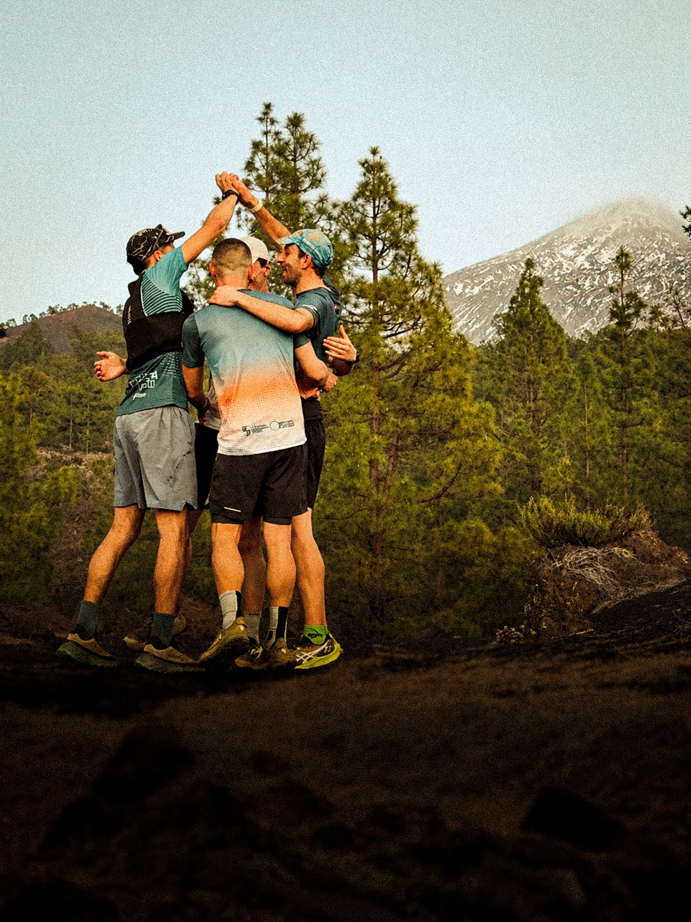 Corredores celebrando frente a montañas nevadas